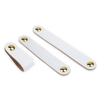 Drie Tomasso White leren handgrepen van yessential.nl met gouden drukknopen worden getoond op een witte achtergrond: twee plat gelegd en één gelust.