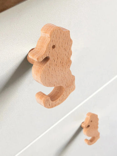 Close-up van twee Bambino Seahorse houten deurknoppen van yessential.nl op een lichte lade - ideaal voor de kinderkamer - met de ene knop scherp en de andere zachtjes onscherp op de achtergrond.