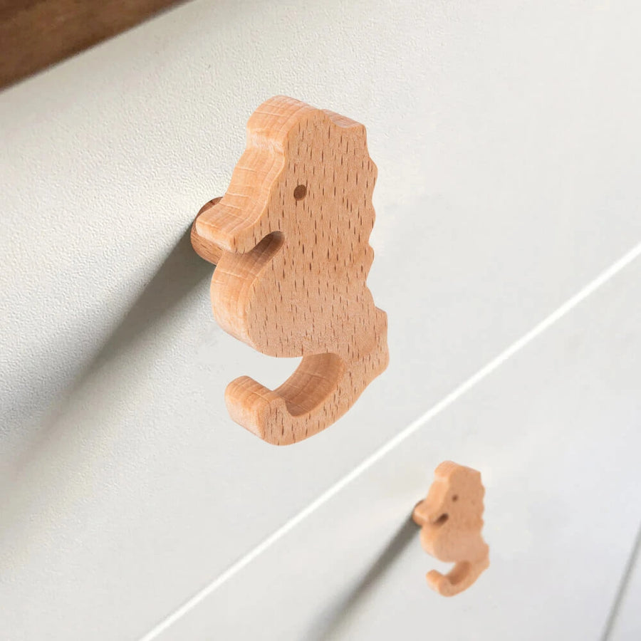 Close-up van twee Bambino Seahorse houten deurknoppen van yessential.nl op een lichte lade - ideaal voor de kinderkamer - met de ene knop scherp en de andere zachtjes onscherp op de achtergrond.