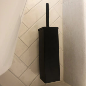 De Moreno Black WC-set van yessential.nl heeft een matzwarte, rechthoekige toiletborstelgarnituur met handgreep, aan de muur gemonteerd op crèmekleurige diagonale tegels-een stijlvolle aanvulling op je badkameraccessoires of toiletaccessoires.