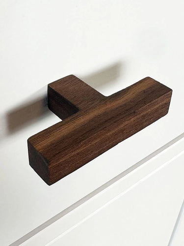 De Vigio Walnut knop van yessential.nl is geïnstalleerd op een wit kastfront met eenvoudige paneeldetaillering.