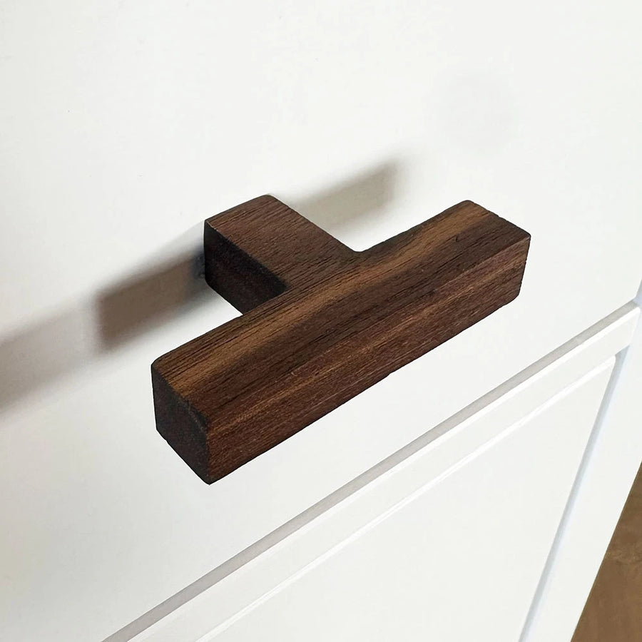 De Vigio Walnut knop van yessential.nl is geïnstalleerd op een wit kastfront met eenvoudige paneeldetaillering.