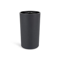 De Sicco Black 10cm van yessential.nl is een zwarte cilindrische beker met een matte afwerking en een rand met een kruispatroon. De beker staat rechtop op een witte achtergrond en weerspiegelt de strakke stijl van zwarte ronde meubelpootjes.